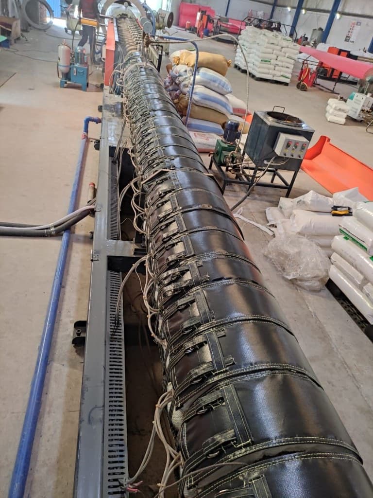 Long extruder barrel wrapped in quilted ThermoSave insulation jackets