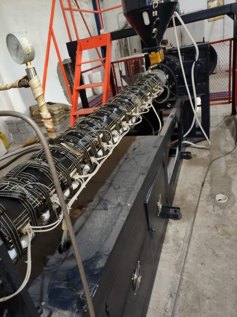 Extruder with insulation jackets, pressure gauges, and orange control cabinet